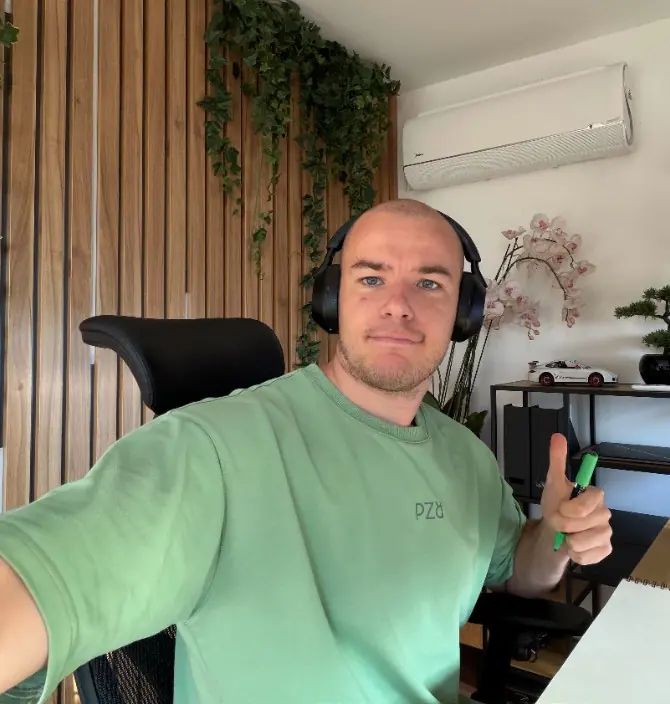 Marko Živić at his desk in headphones, holding a green marker